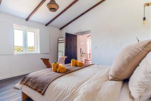 um quarto com uma cama grande com almofadas amarelas em Casa Alfambras - Holiday Cottage in Aljezur em Aljezur