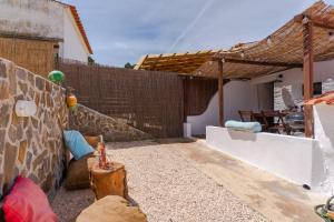 Casa Alfambras - Holiday Cottage in Aljezur في ألخيزور: حديقة خلفية مع سور خشبي وطاولة