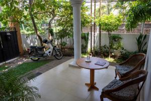 un patio con una mesa y un scooter aparcado en un patio en The Tourist Balcony, en Negombo