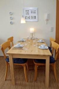 a dining room table with chairs and a wooden tableablish at Yachthafenresidenz-Wohnung-9107-829 in Kühlungsborn