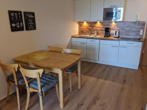 a small kitchen with a wooden table and chairs at Yachthafenresidenz-Wohnung-5303-815 in Kühlungsborn