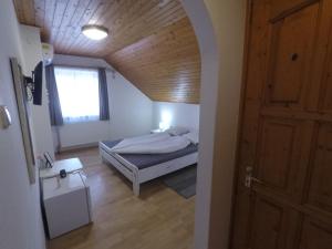 um quarto com uma cama e um tecto de madeira em Napsütötte Kehida em Kehidakustány