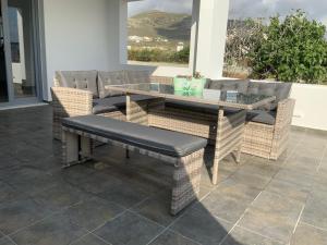 a patio with a table and wicker chairs at Villa NanSea in Kastraki