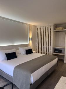 プエルト・ナタレスにあるHotel Costaneraのベッドルーム(白いシーツを使用した大型ベッド1台付)