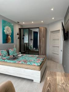 a bedroom with a large bed and a large mirror at Квартира по вул. Огієнка 2а in Lutsk