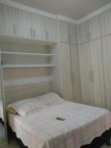 a small bedroom with a bed and white cabinets at Quarto e Sala completo in Rio de Janeiro