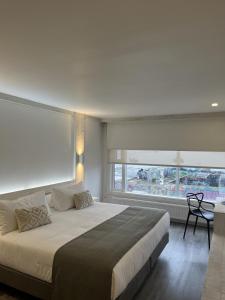 プエルト・ナタレスにあるHotel Costaneraのベッドルーム1室(大きなベッド1台、大きな窓付)