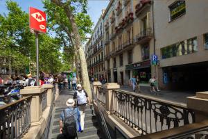 um grupo de pessoas andando por uma rua da cidade em Hostal Boqueria em Barcelona