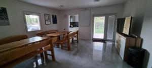 a kitchen with wooden tables and benches in a room at Chata nad kúpaliskom Santovka in Santovka