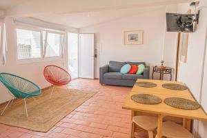 - un salon avec une table, des chaises et un canapé dans l'établissement Colors Pool House, à Carvoeiro