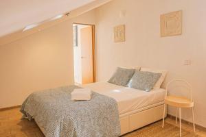 ein kleines Schlafzimmer mit einem Bett und einem Stuhl in der Unterkunft Colors Pool House in Carvoeiro + 33 Fotos