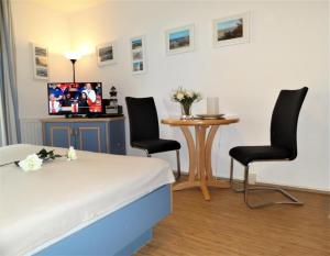 a bedroom with a bed and two chairs and a table at Yachthafenresidenz-Wohnung-8109-847 in Kühlungsborn