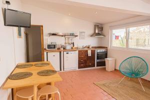 Il comprend une cuisine avec une table et des chaises en bois. dans l'établissement Colors Pool House, à Carvoeiro