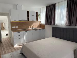 1 dormitorio con 1 cama y lavamanos y cocina en Студио Симона 5 първа линия море en Lozenets