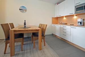 キュールングスボルンにあるYachthafenresidenz-Wohnung-8303-859のキッチン(木製のテーブル、椅子付)