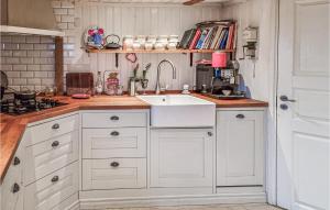 a kitchen with white cabinets and a sink at Pet Friendly Home In Vstra Tunhem With House A Panoramic View in Västra Tunhem