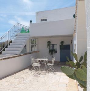 a patio with a table and chairs and stairs at I Trulli di Nonna Maria in Alberobello