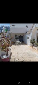 a patio with a table and chairs and a building at I Trulli di Nonna Maria in Alberobello