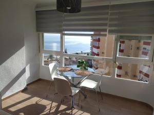 Un comedor con mesa y sillas y una ventana. en Apartamento Peñalver 813, en Torrox Costa