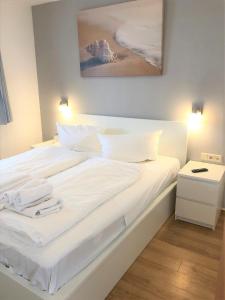 a white bed with white sheets and pillows at Yachthafenresidenz-Wohnung-9106-881 in Kühlungsborn