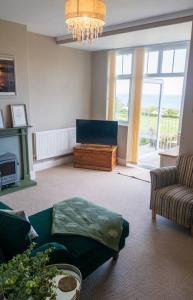 a living room with a couch and a table at Cae Glas in Penmaen-mawr