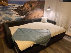 Bett in einem Schlafzimmer mit Wandgemälde in der Unterkunft Yachthafenresidenz - Wohnung 9103 / 879 in Kühlungsborn
