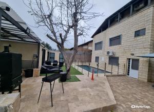 a courtyard with a tree in front of a building at אחוזת רזים - Villa Razim in Safed