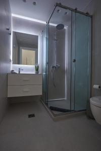 a bathroom with a shower and a sink and a toilet at Corfu Venetian Luxury Apartment in Corfu Town +10 photos