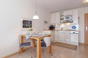 a kitchen with a table and chairs in a room at Yachthafenresidenz-Wohnung-8403-908 in Kühlungsborn