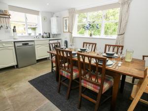 a kitchen with a wooden table and chairs in a kitchen at Nash Cottage in Leominster