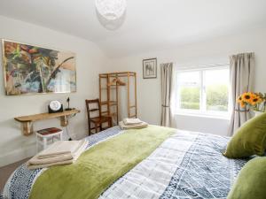 sypialnia z dużym łóżkiem i oknem w obiekcie Nash Cottage w mieście Leominster