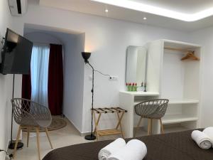 a room with a bed and two chairs and a television at Villa NanSea in Kastraki
