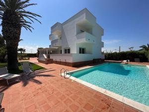 a villa with a swimming pool in front of a house at Villa Antonia sul mare con piscina Torre a mare (Bari) in Bari