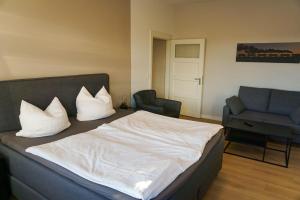 キュールングスボルンにあるFerienwohnungen-Molli-West-Wohnung-1-9801のベッドルーム1室(ベッド1台、ソファ、椅子付)