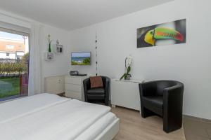 a bedroom with a bed and a desk and two chairs at Yachthafenresidenz-Wohnung-8105-9733 in Kühlungsborn