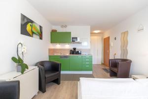 Zimmer mit einem Bett und Stühlen sowie einer Küche in der Unterkunft Yachthafenresidenz - Wohnung 8105 / 9733 in Kühlungsborn