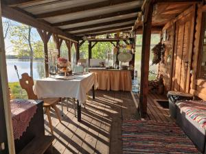 a dining room with a table on a wooden house at Mini saunahouse in Bašķi