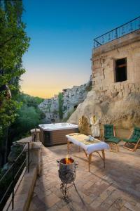 a patio with a hot tub and a fire pit at Cappadocia Splendid Cave Hotel in Ortahisar