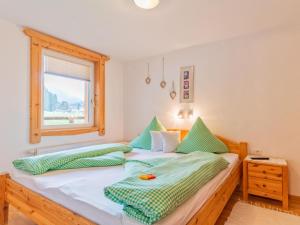 a bedroom with a bed with green and white pillows at Migglwieshof in Kelchsau