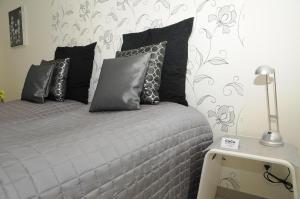 a bedroom with a bed with black and gray pillows at Hotel CoCo Aps in Esbjerg