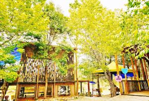 a wooden building with trees and a playground at Fun星空謐境 埔里包棟民宿 烤肉麻將自然園區 in Puli