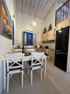 哈爾基的住宿－Casa Porphyra，厨房配有白色的桌椅和黑冰箱。