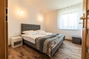 een slaapkamer met een bed en een raam bij Apartamenty Henry in Łeba