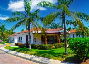 a house with palm trees in front of it at Las Veraneras Villas & Resort in Acajutla