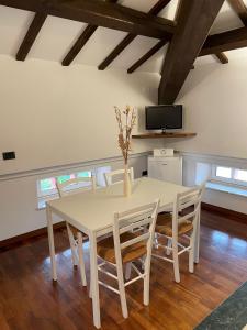 a white dining room table with chairs and a tv at Villa Livia in Fermo