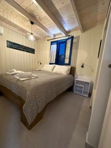 a bedroom with a large bed with a window at Casa Porphyra in Halki