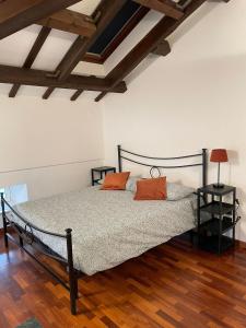 ein Schlafzimmer mit einem Bett mit zwei orangenen Kissen darauf in der Unterkunft Villa Livia in Fermo