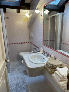 W łazience znajduje się umywalka, toaleta i lustro. w obiekcie Villa Livia w mieście Fermo