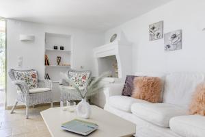 uma sala de estar branca com um sofá branco e cadeiras em Vainas Belvedere Villa em Skopelos