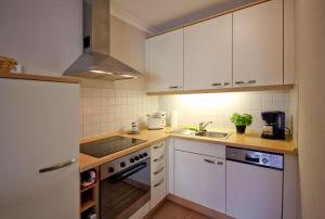 キュールングスボルンにあるResidenz-Ostseestrand-WE-15-9876の小さなキッチン(白いキャビネット、シンク付)